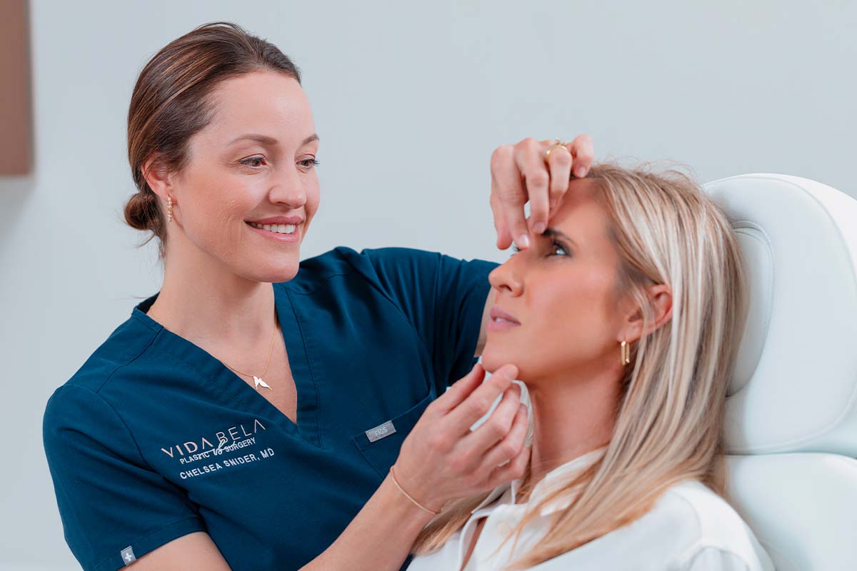 Dr. Snider examining a patient’s nose during a revision rhinoplasty consultation